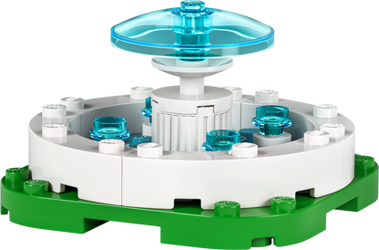 Colorful LEGO build featuring a fountain design with transparent blue pieces on a green base