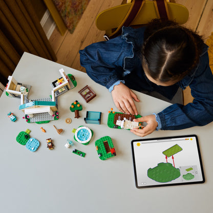 Child building a LEGO set on a table with various colorful pieces and a tablet nearby