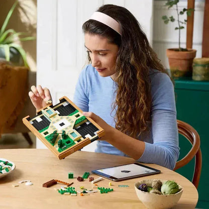 Woman assembling the lego botanical garden set with colorful pieces on a wooden table