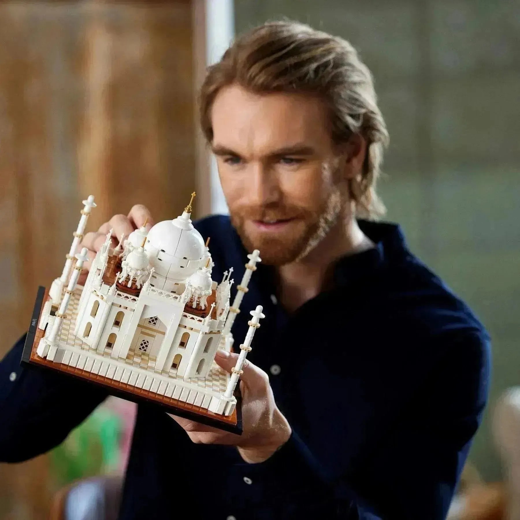 Person holding a detailed LEGO Architecture Taj Mahal model with intricate designs and features